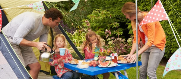 Familie beim gemeinsamen Essen am Campingtisch auf dem Stellplatz – entspannter Moment im Campingurlaub
