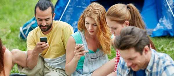 Camper mit Smartphone auf dem Campingplatz – mobile Geräte, Powerbank und digitale Helfer im Campingurlaub