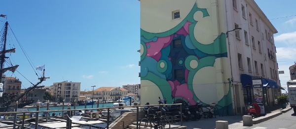 Bunte Street Art auf einer Hauswand im Hafenviertel von Sète – kreative Wandmalerei als Teil der lebendigen Stadtkultur