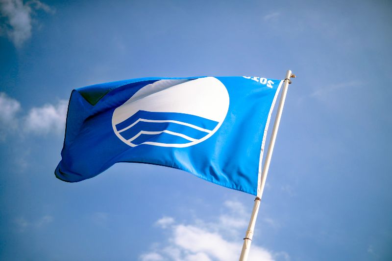 Sehen Sie diese Flagge wehen? Dann erfüllt der Strand die Nachhaltigkeitskriterien für die Blue-Flag-Zertifizierung.