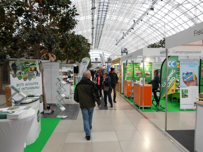 Ruhiger Moment am ACSI-Stand auf der Campingmesse in Leipzig, ein paar Besucher schlendern durch den Gang.
