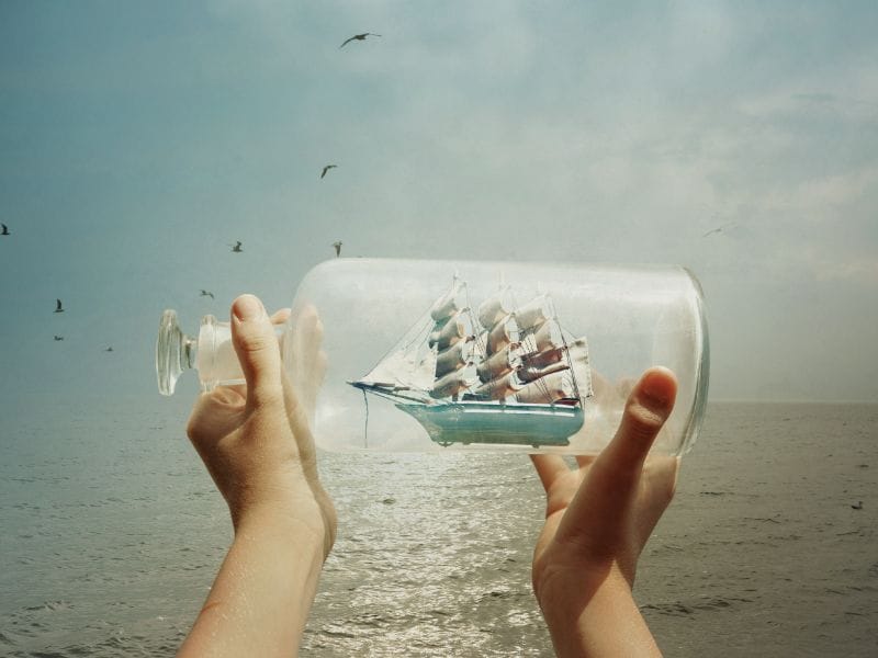 Segelschiff in Glasflasche vor Weltmeer als Hintergrund-Urlaub auf Texel