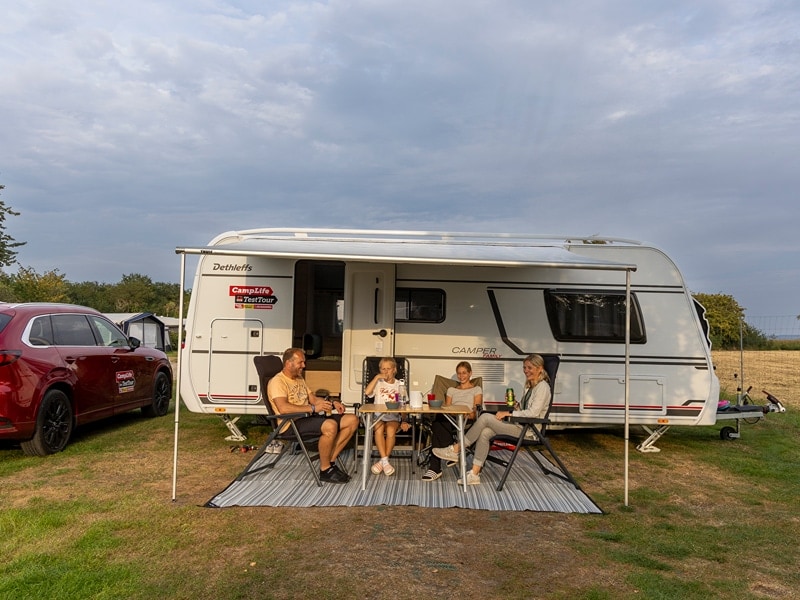 Die Rienhoffs sitzen am Tisch unter der Markise ihres Caravans