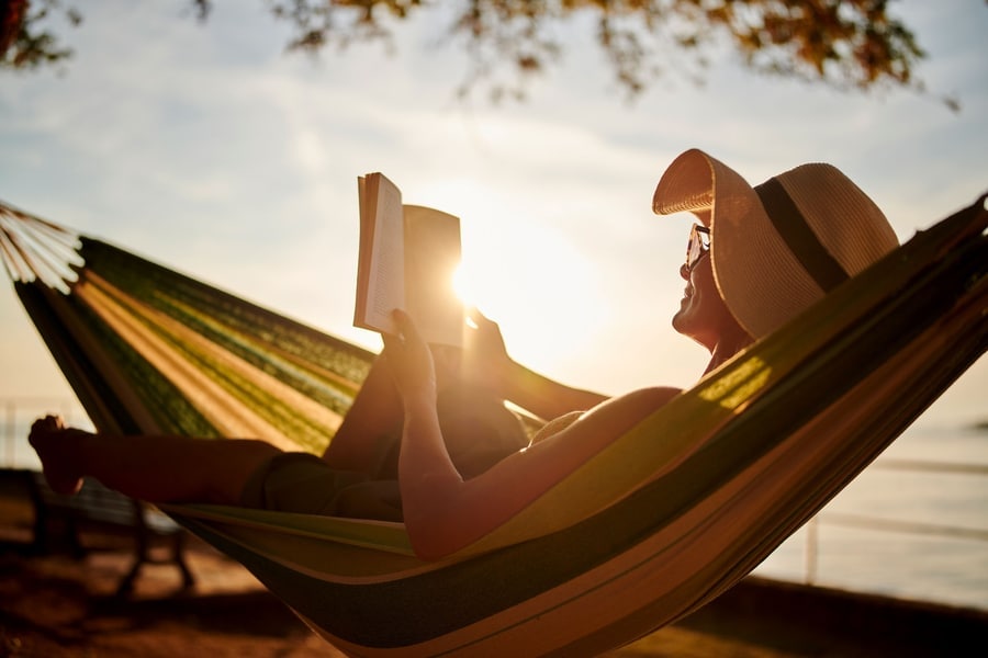 Frau liest ein Buch in einer Hängematte