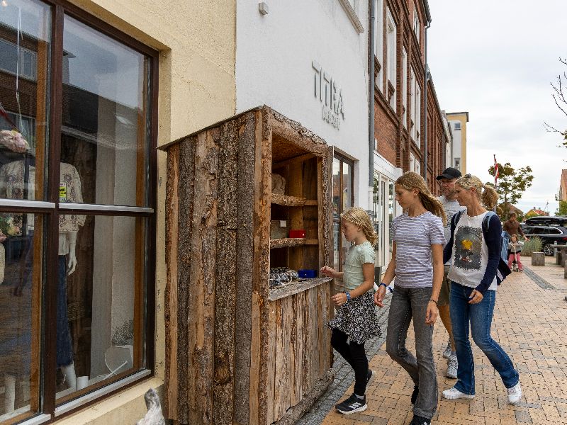 Die Rienhoffs schauen sich Gegenstände in einem kleinen Verkaufsstand mit lokalen Produkten an
