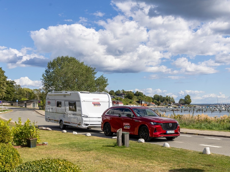 Gespann aus Mazda CX-80 und Dethleffs Caravan vor der Küste in Dänemark