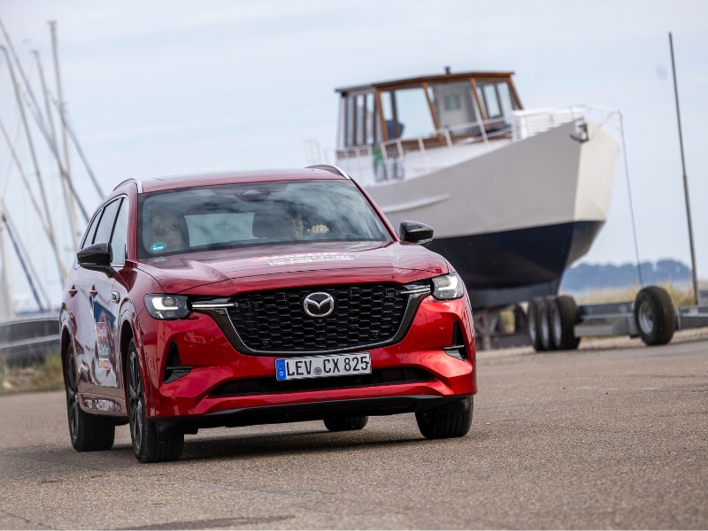 Mazda CX-80 im Hafen mit Boot im Hintergrund.