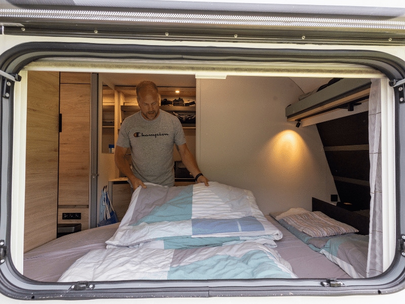Jens macht das Bett im Familienwohnwagen