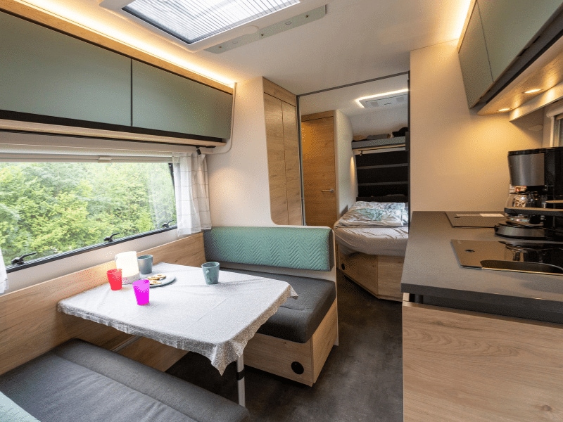 Blick in den Familienwohnwagen: Sitzgruppe, Küchenzeile und Elternbett
