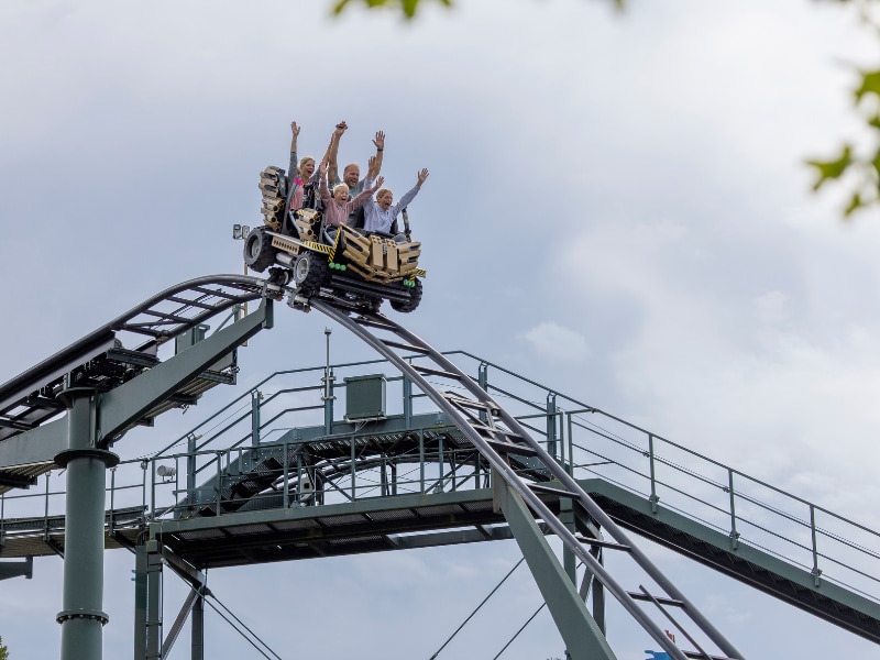 Die vier Rienhoffs mit in die Luft gestreckten Händen in einer Achterbahn sitzend.