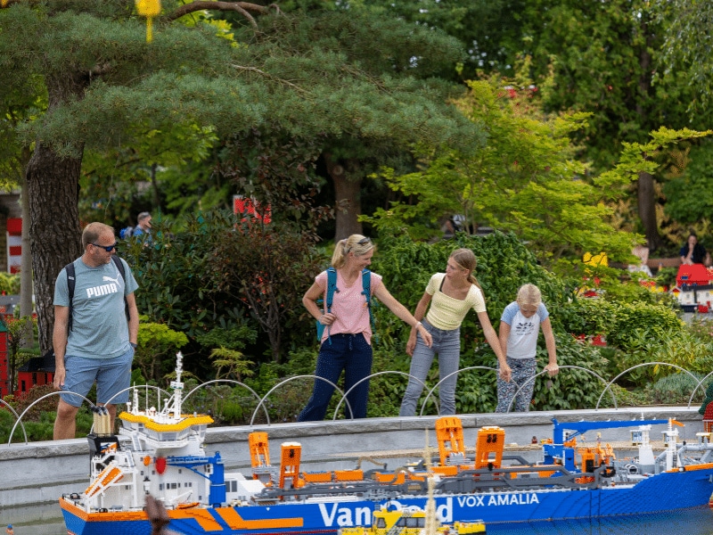 Jens, Petra, Miriam und Leonie bestaunen das Containerschiff aus Legosteinen.