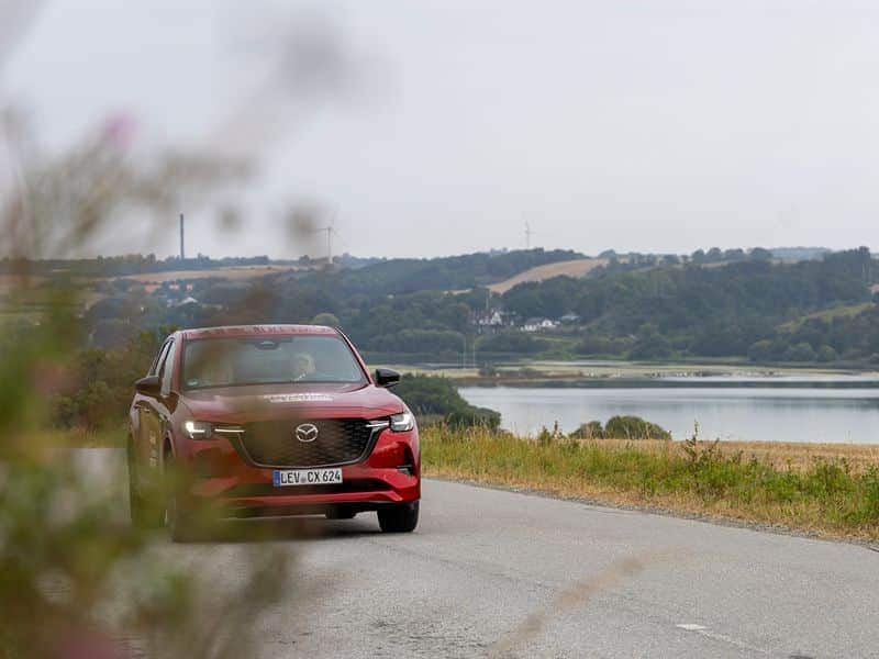 Mazda CX-60 in der dänischen Landschaft mit Fjord im Hintergrund