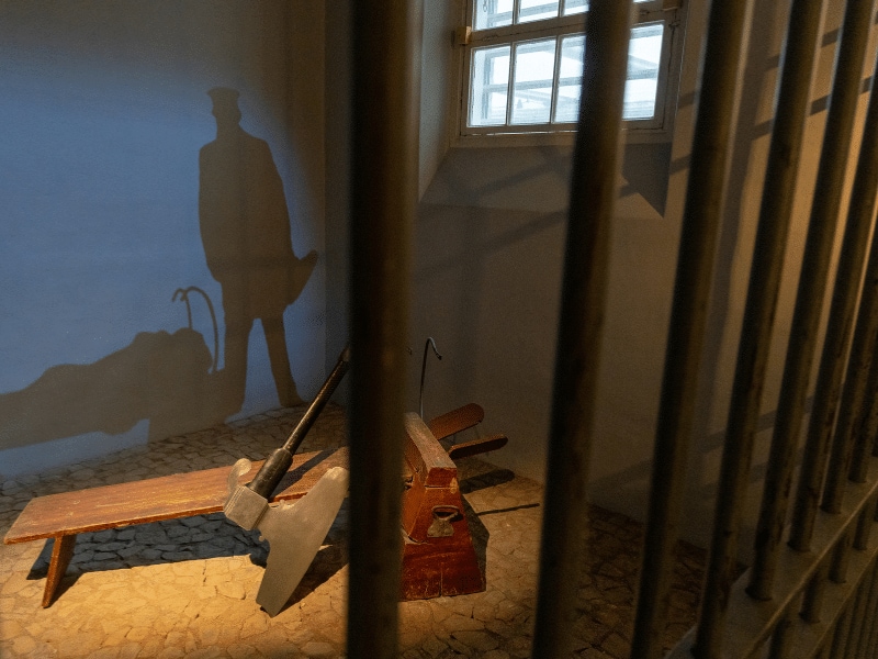 Henkersbeil hinter Gittern mit Schatten