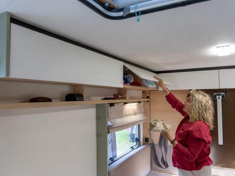 Herta verstaut etwas in einem der vielen Hängeschränke