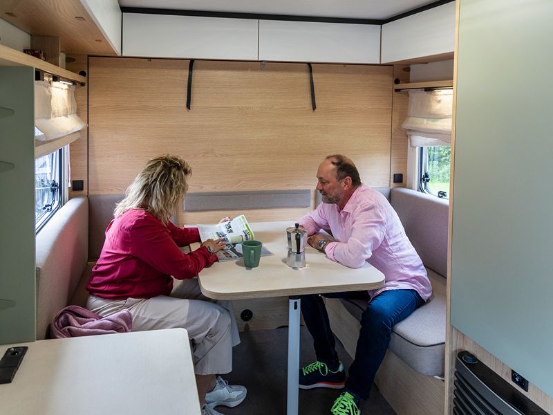 Herta und Frank sitzen am Esstisch und blättern in einer Zeistchrift