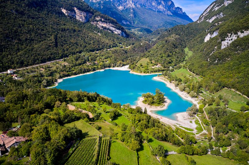 Luftaufnahme des türkisfarbenen Lago di Tenno inmitten der Berglandschaft.