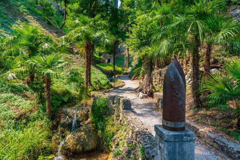 Pfad mit exotischen Pflanzen, Palmen und Wasserlauf im botanischen Heller Garden.