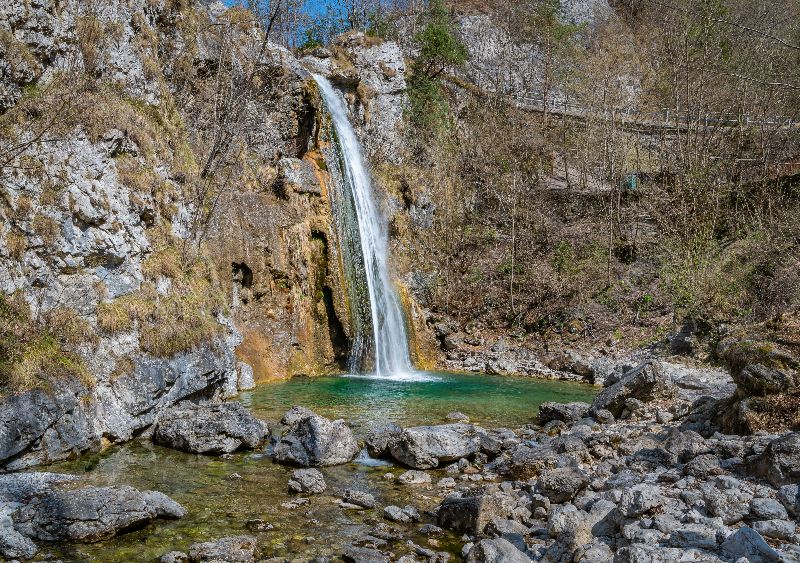Wasserfall in einer Felslandschaft mit klarem Becken und umliegenden Felsen in den Bergen nahe des Gardasees.