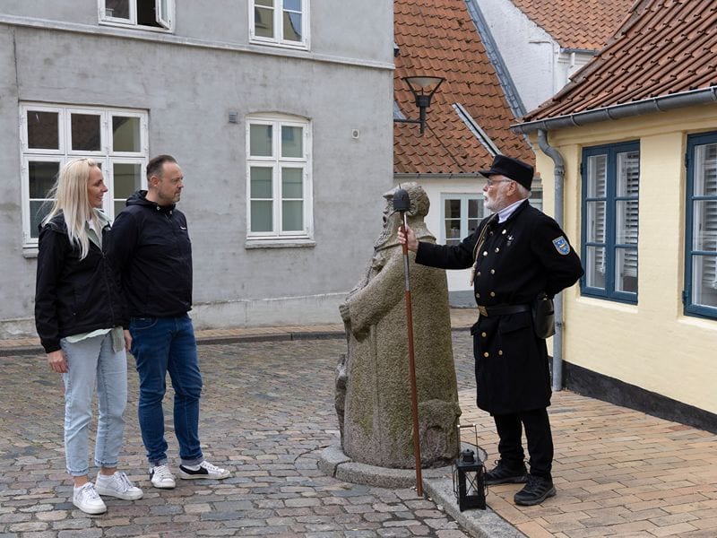 Ricarda und Lars schauen zum Nachtwächter neben der Nachtwächterstatue.