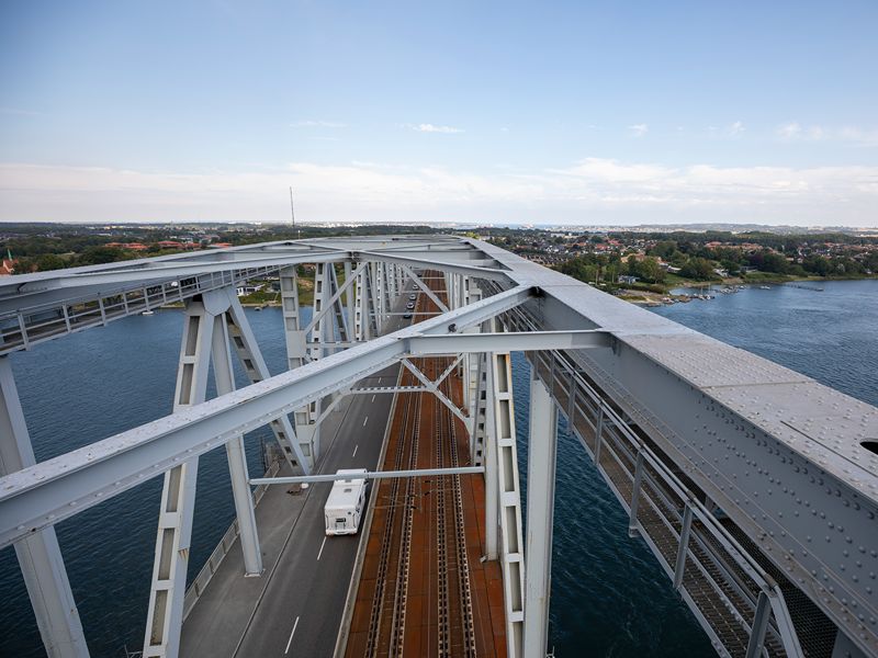 Brücke über Dänemark. Blick nach unten auf Straße und Eisenbahnschienen.