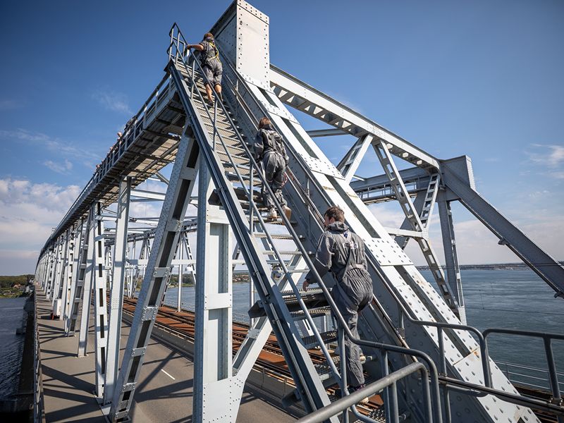 Gesichert geht es graue Treppen hinauf bis zum höchsten Punkt der Brücke