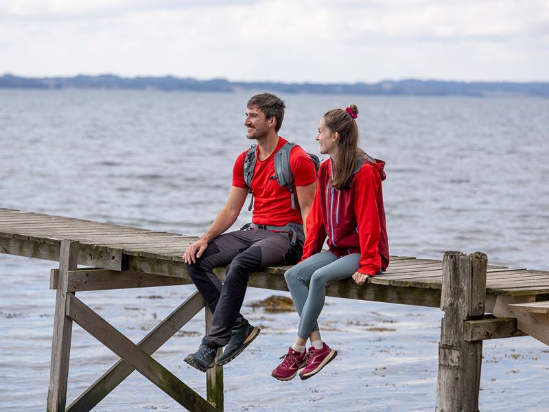Maja und Felix sitzen auf dem Steg in der Nähe des Sondrup Strands