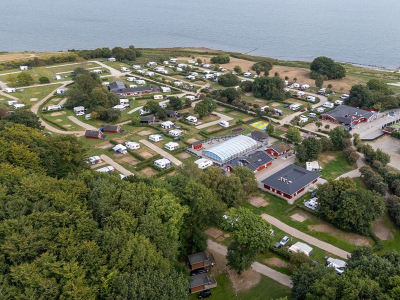 Ansicht des Campingplatzes von oben, mit den Sanitärgebäuden, überdachten Schwimmbad und den Unterkünften