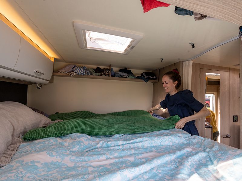 Maja macht das Bett im Camper. Dieser bietet viel Abstellfläche
