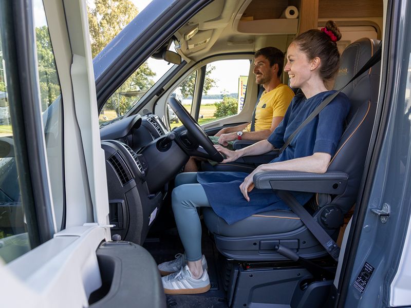 Maja und Felix sitzen angeschnallt im Bürstner auf dem Campingplatz