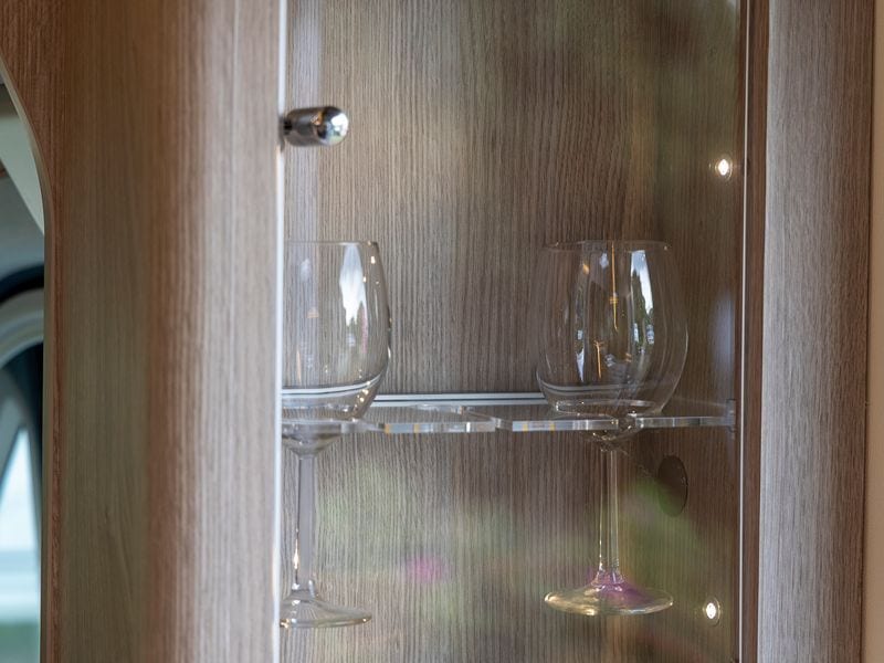 Zwei Weingläser im Weinschrank mit hellem Holz und Glastür