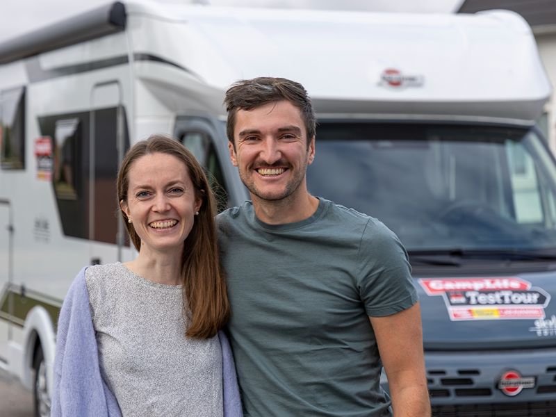 Maja und Felix stehen lächelnd vor ihrem Camper