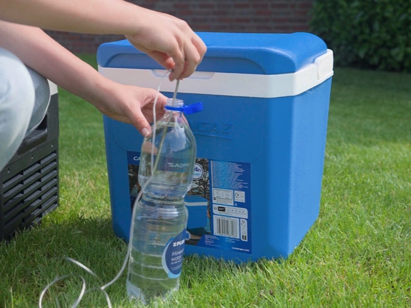 Flasche mit Thermometer vor der Kühlbox