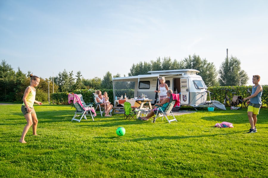 Kinder spielen vor dem Wohnwagen