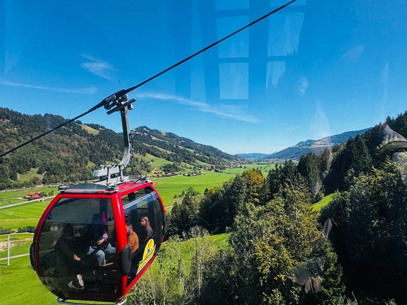 Rote Gondel der Hündlebahn zwischen den bayrischen Voralpen.