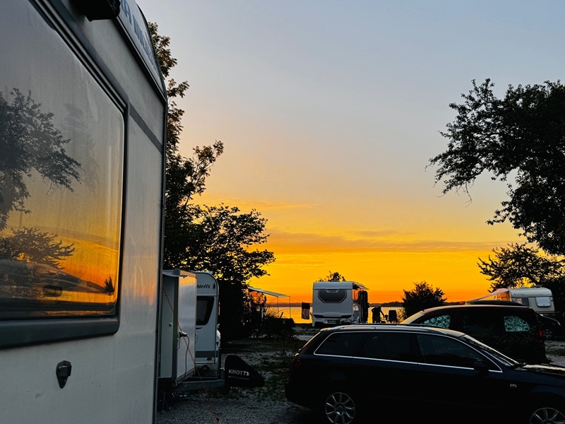 Blick vom Campingplatz über den See mit Sonnenuntergängen