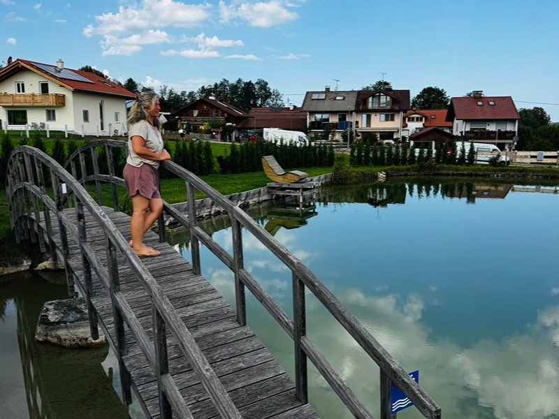 Laima steht auf der Brücke über den Schwimmteich